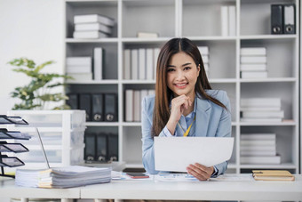 微笑漂亮的业务亚洲女人工作工作移动PC电脑现代办公室会计分析报告真正的房地产投资数据金融税系统概念
