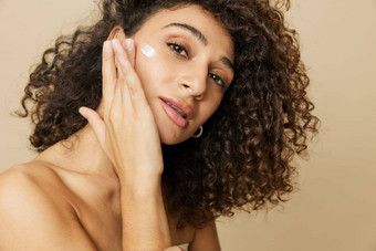 女人美脸特写镜头应用抗衰老保湿霜手指手皮肤健康指甲头发头发干燥机风格卷曲的非洲式发型头发身体美护理概念