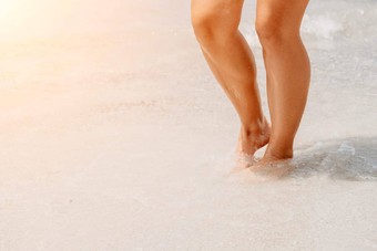 海海滩旅行女人走沙子海滩离开的足迹白色沙子女腿走海边光着脚特写镜头晒黑腿女孩<strong>未来</strong>水