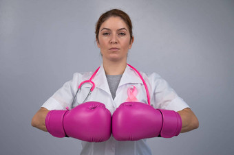 女医生粉红色的拳击手套粉红色的丝带灰色的背景战斗乳房癌症