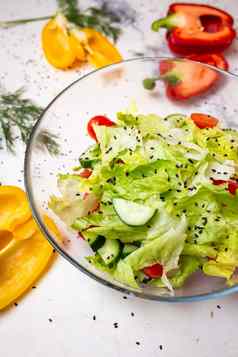 素食者沙拉新鲜的蔬菜生菜芝麻西红柿沙拉玻璃杯前视图