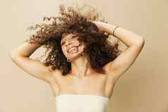 女人适用于奶油乳香卷曲的头发概念保护护理健康的微笑牙齿米色背景