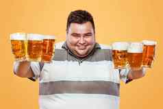 年轻的脂肪男人。啤酒节喝啤酒黄色的背景