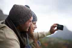 捕捉时刻年轻的夫妇采取照片徒步旅行山