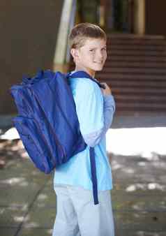 回来学校微笑年轻的男孩穿背包学校肖像