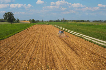 高级农民开车爬拖拉机耕种干场播种无人机拍摄