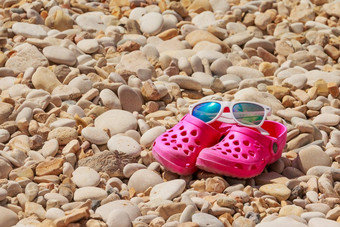色彩斑斓的孩子们凉鞋卵石海滩儿童夏天塑料鞋子夏天太阳镜岩石海滩复制空间