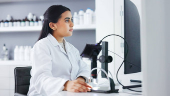 年轻的科学家电脑显微镜实验室女病理学家分析医疗样品实验开发治愈微生物学家进行法医研究