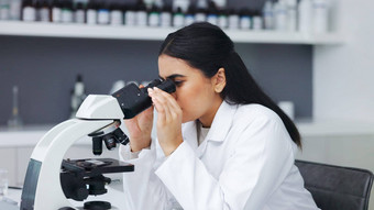女科学家显微镜研究实验室年轻的生物学家生物技术研究员工作分析微观样品最新的实验室科技设备