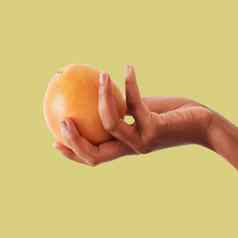 手橙色水果维生素健康的饮食计划营养工作室背景手持有水果食物高丽油桃葡萄柚健康有机健康柑橘类模型