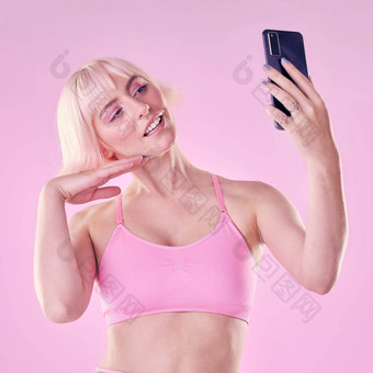 自拍美女人工作室化妆化妆品脸例程手机化妆品风格女模型澳大利亚采取图片电话孤立的粉红色的背景