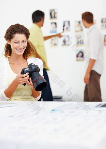 微笑女摄影师查看图片相机<strong>肖像</strong>微笑女摄影师查看图片相机的同事们背景