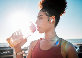 喝水健身黑色的女人海滩锻炼听音乐有氧运动培训蓝色的天空镜头耀斑液体瓶饮食目标累了体育跑步者美国人海洋
