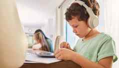 孩子耳机平板电脑教育学习首页表格互联网连接男孩孩子技术教育移动应用程序流媒体视频电影听声音