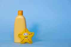 黄色的布局孩子们的化妆品产品的地方标志有趣的玩具蓝色的背景婴儿洗发水淋浴过来这里身体乳液空间文本