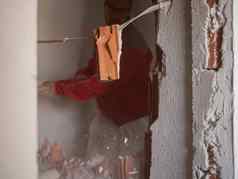 拆迁工作首页改造建设工人打碎墙大锤粒子石膏片段砖散射方向强大的打击