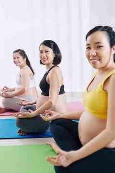 集团年轻的怀孕了亚洲女性练习瑜伽类