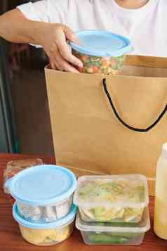 裁剪图像女人采取容器新鲜的沙拉减少水果大纸袋交付在线商店