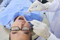 亚洲男人。穿眼镜常规的牙科考试诊所水平关闭拍摄