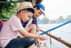 13岁以下的亚洲男孩设置卷杆时间钓鱼父亲周日早....