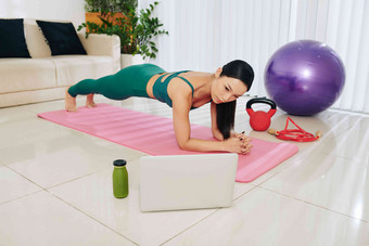 苗条的亚洲女人站<strong>板材</strong>位置健身教程移动PC屏幕
