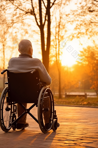 坐在轮椅上看夕阳的老人侧影公园