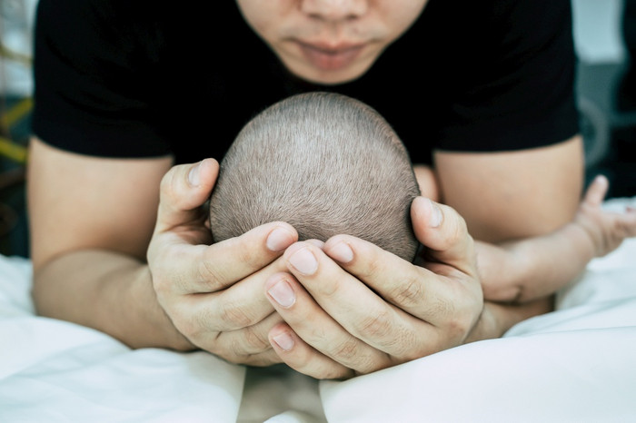 婴儿睡在父亲的手中有选择的焦点图片