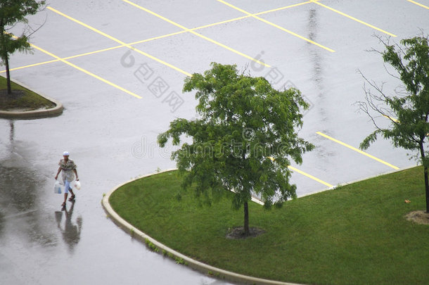 空旷潮湿停车场的孤独行人