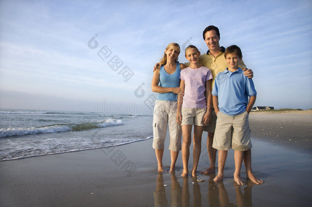 海滩上微笑的一家人。