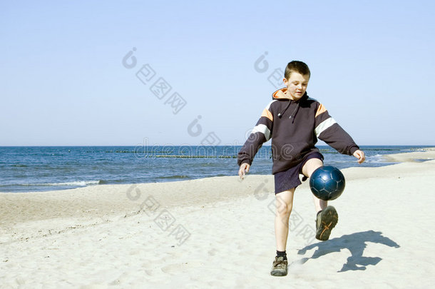 在沙滩上打球的男孩。