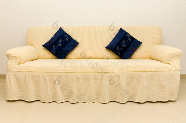 米色沙发和蓝色靠垫。