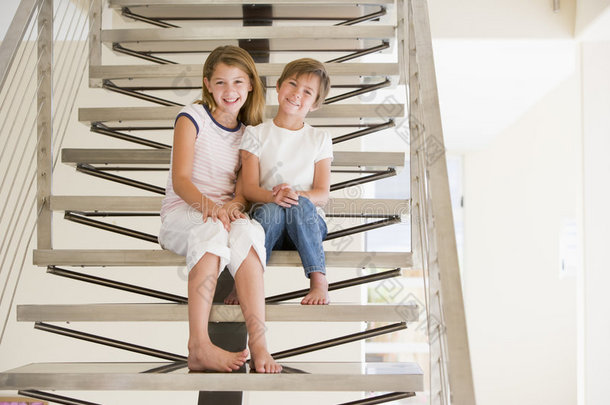 两个年轻女孩坐在家里的楼梯上
