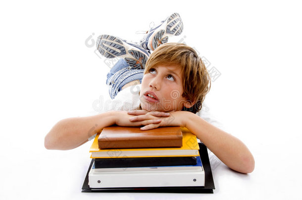 抱着书躺着的男孩的正面图