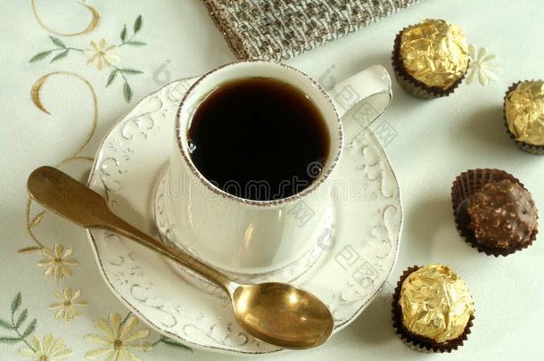 一杯茶和巧克力糖放在漂亮的小报上