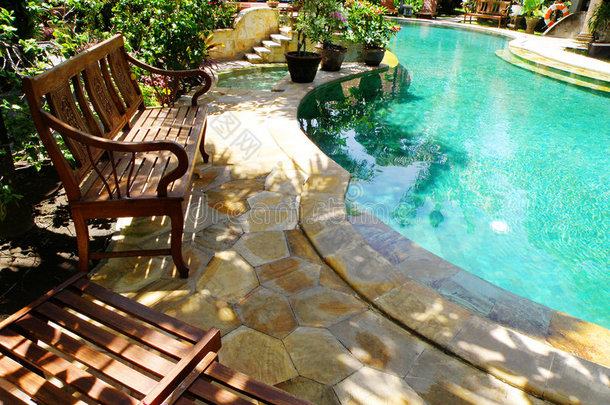 阳光明媚的室外游泳池和庭院家具