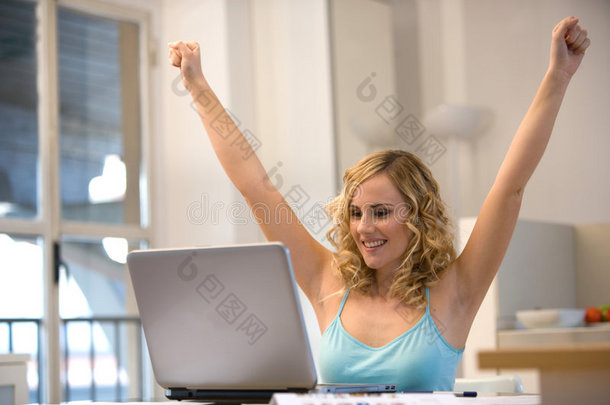 手提电脑旁的女人举起手臂