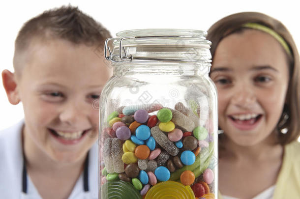 女孩和男孩看着甜罐子