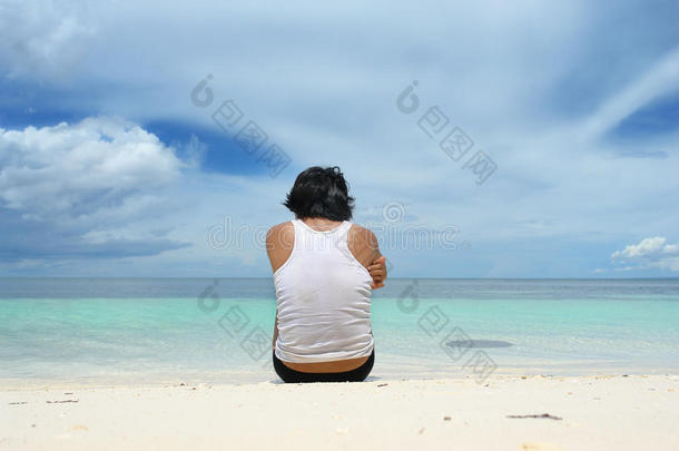 孤独地坐在沙滩上的男人