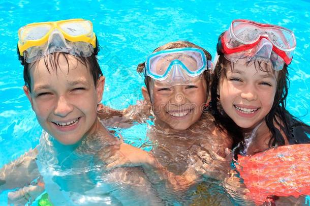 三个快乐的孩子在游泳池里