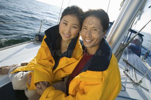 一对夫妇在游艇上穿着黄色的<strong>风衣</strong>