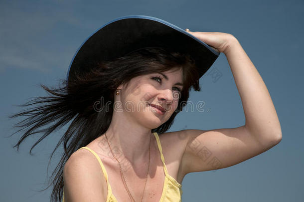 一个戴帽子的女孩，背景是深蓝色的天空