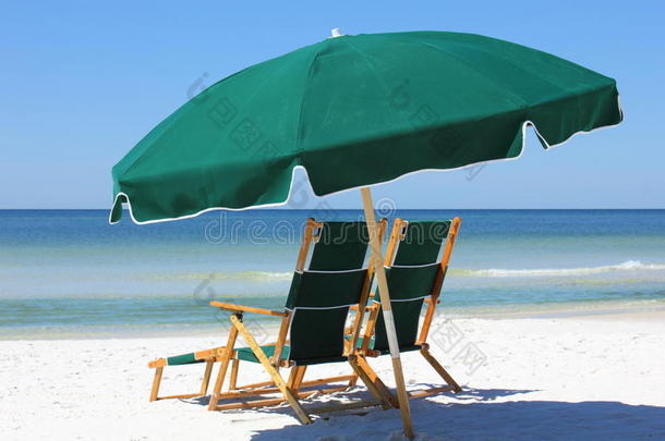 白色沙滩上的两把椅子和雨伞