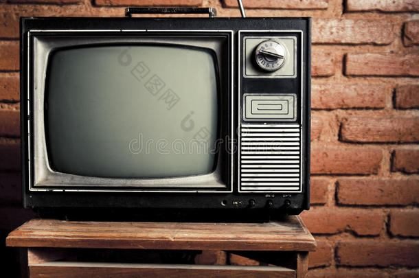 复古的电视机靠在砖墙上。