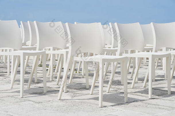 蓝天上的白色椅子群。