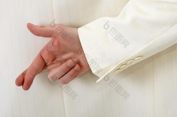 手指交叉在白色西装后面