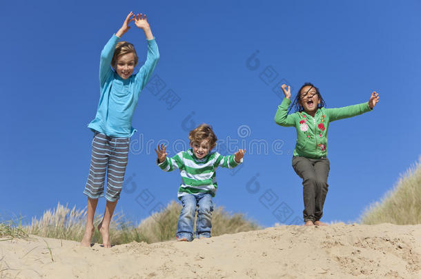 三个孩子在沙滩上玩得很开心
