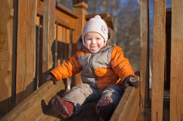 可爱的婴儿从公园的婴儿滑梯上滑下来