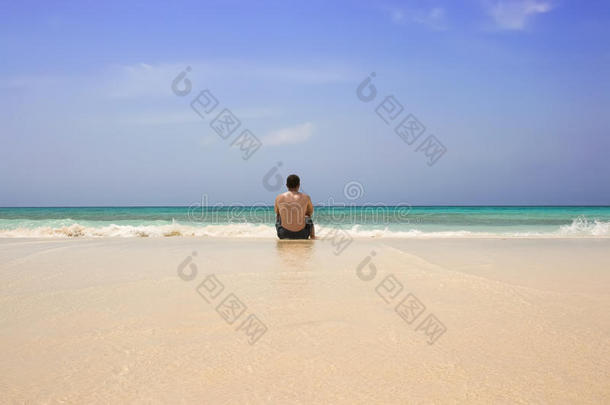 孤独地坐在沙滩上的男人
