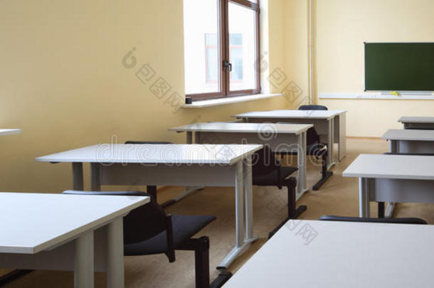 空旷的教室里有课桌和黑色的椅子