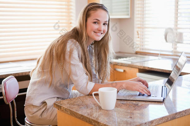 女人边喝咖啡边用笔记本电脑